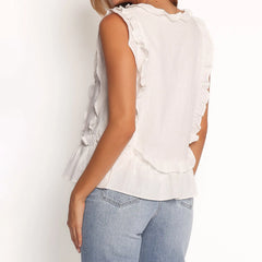 White sleeveless top with ruffles worn by a person on a plain background