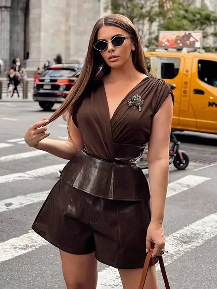 Woman in a brown dress with leather accents on a city street.