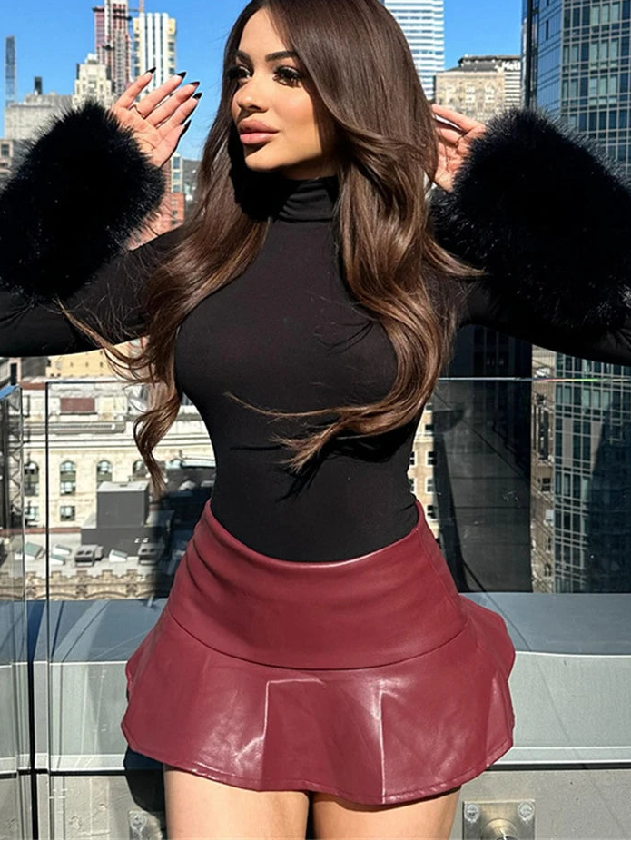 Woman in black turtleneck and red leather skirt with cityscape background