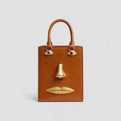 Brown sculptural face structured tote bag with top handle.