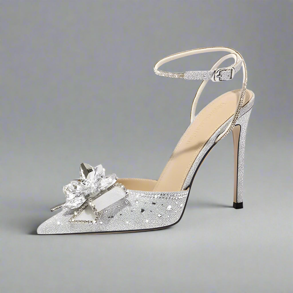 Silver high-heeled shoe with decorative flower on a white background