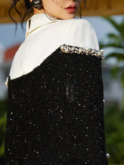 Close-up of a person wearing a black and white outfit with decorative elements.