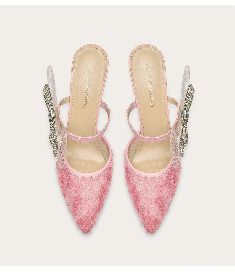 Pink lace high heels with crystal embellishments on a white background