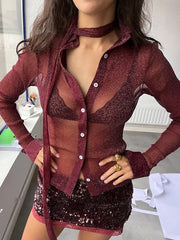 Person wearing a sheer burgundy cardigan over a matching dress with sequins.