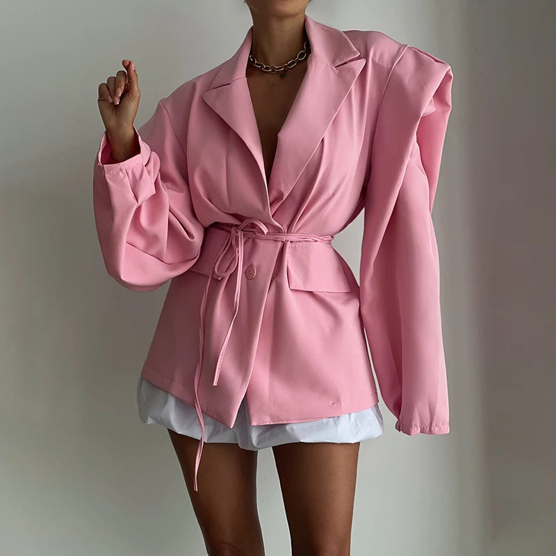 Pink blazer worn by a person on a plain background