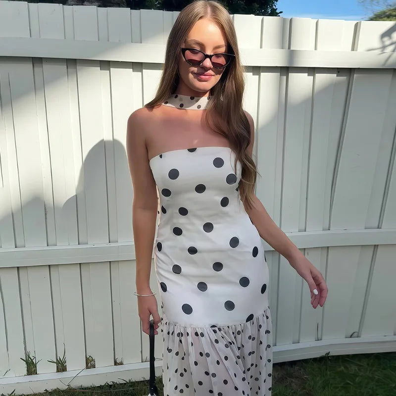 Person posing in a polka dot maxi dress with scarf outdoors