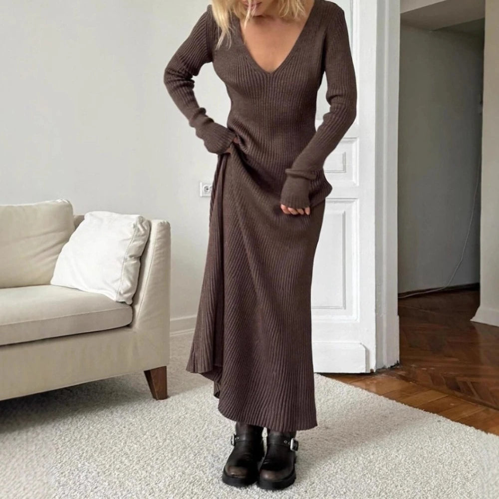 Woman wearing a brown ribbed dress standing in a living room.