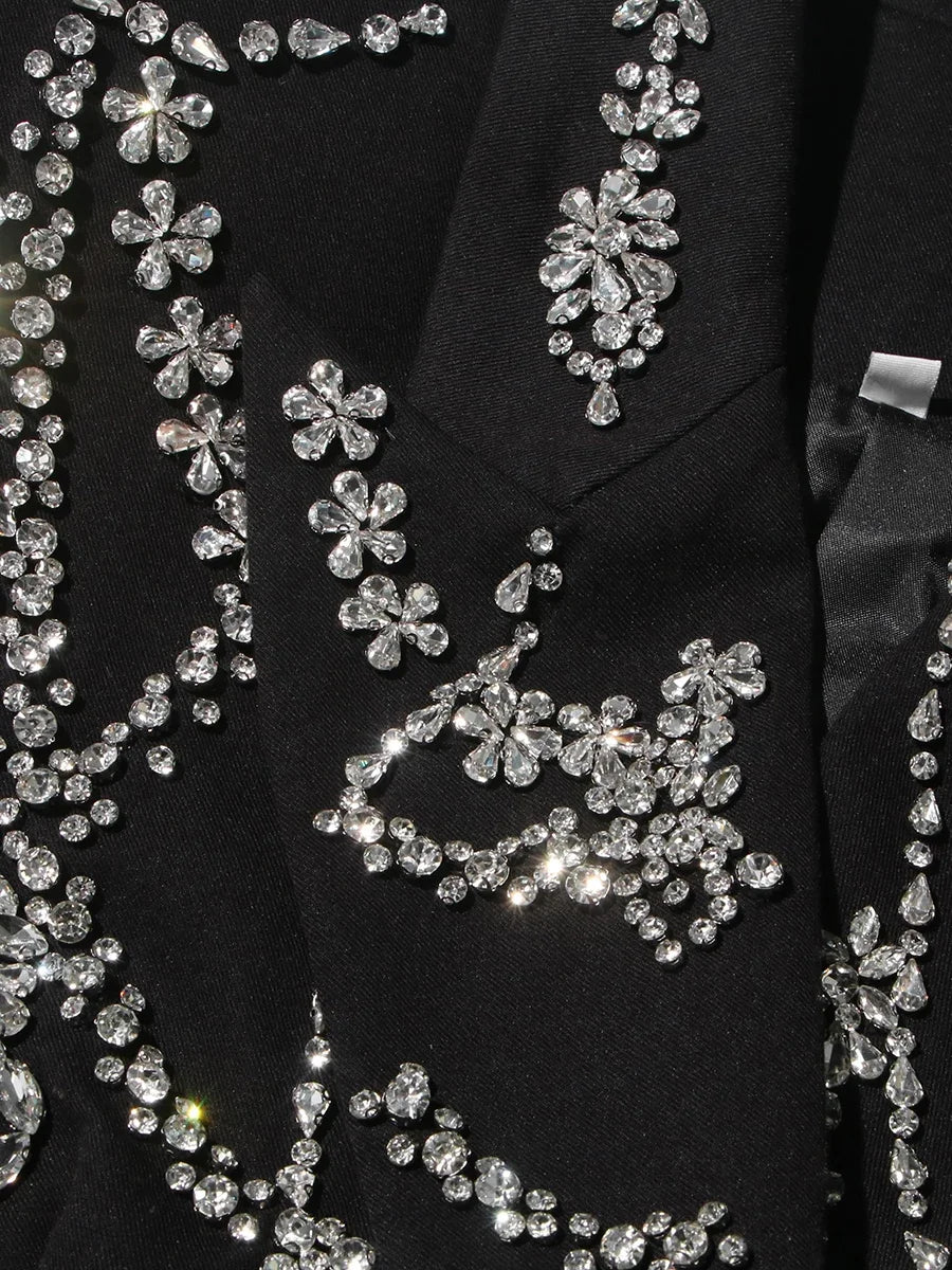 Close-up of a black garment with silver floral embellishments.