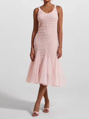 Pink dress with textured bodice and sheer skirt on a white background