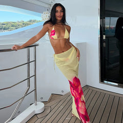 Woman in a colorful outfit standing on a yacht deck.