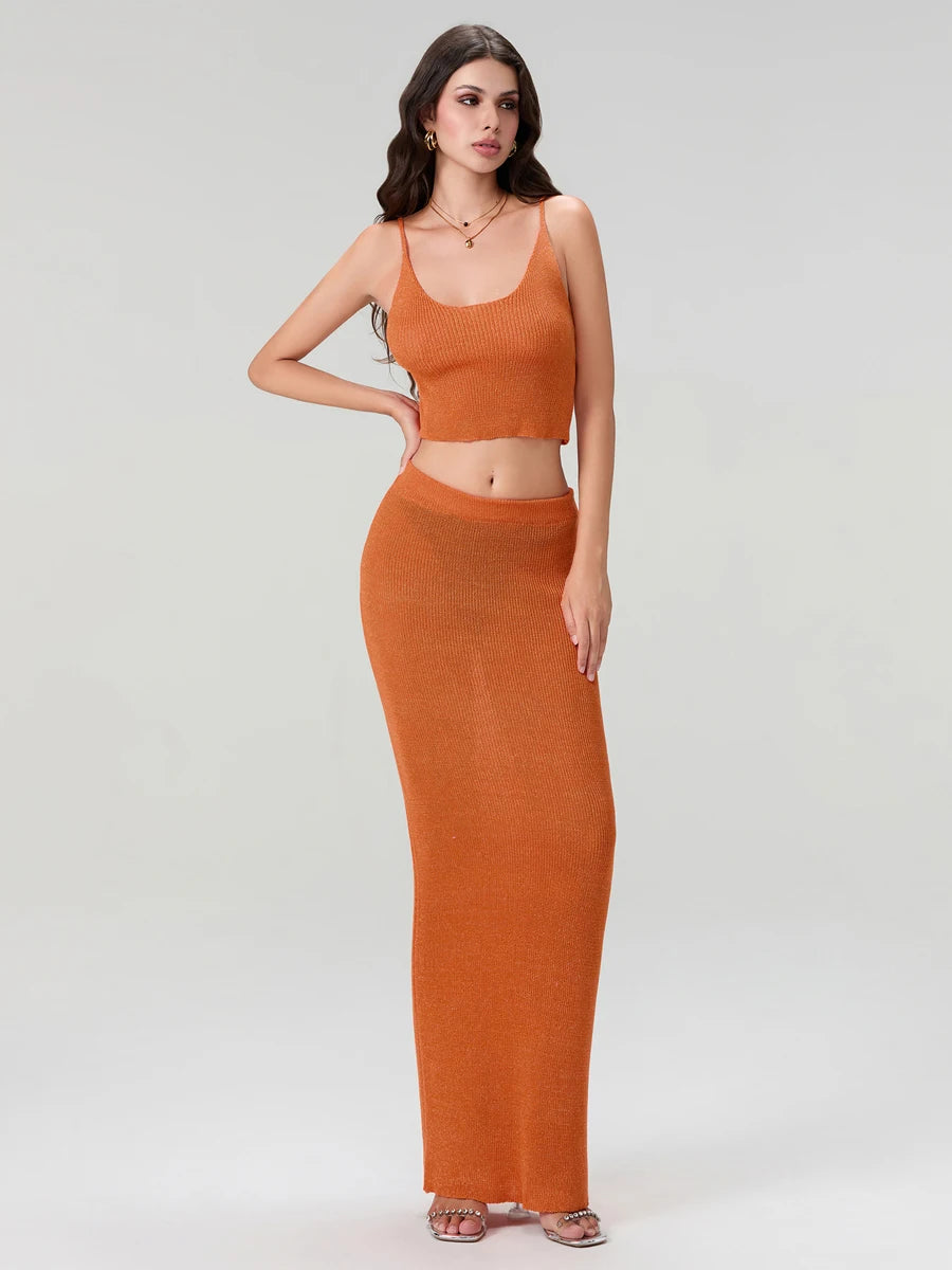 Woman wearing an orange sleeveless top and long skirt on a white background