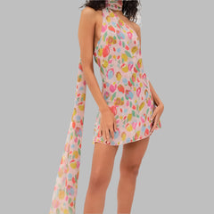 Woman wearing a colorful floral dress with a plain background