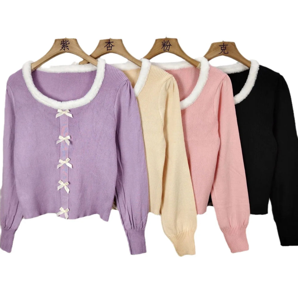 Four sweaters in different colors on hangers with labels above them.