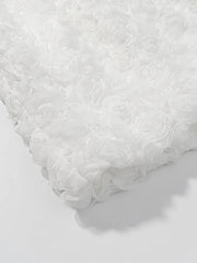 Close-up of a textured white dress on a light gray background