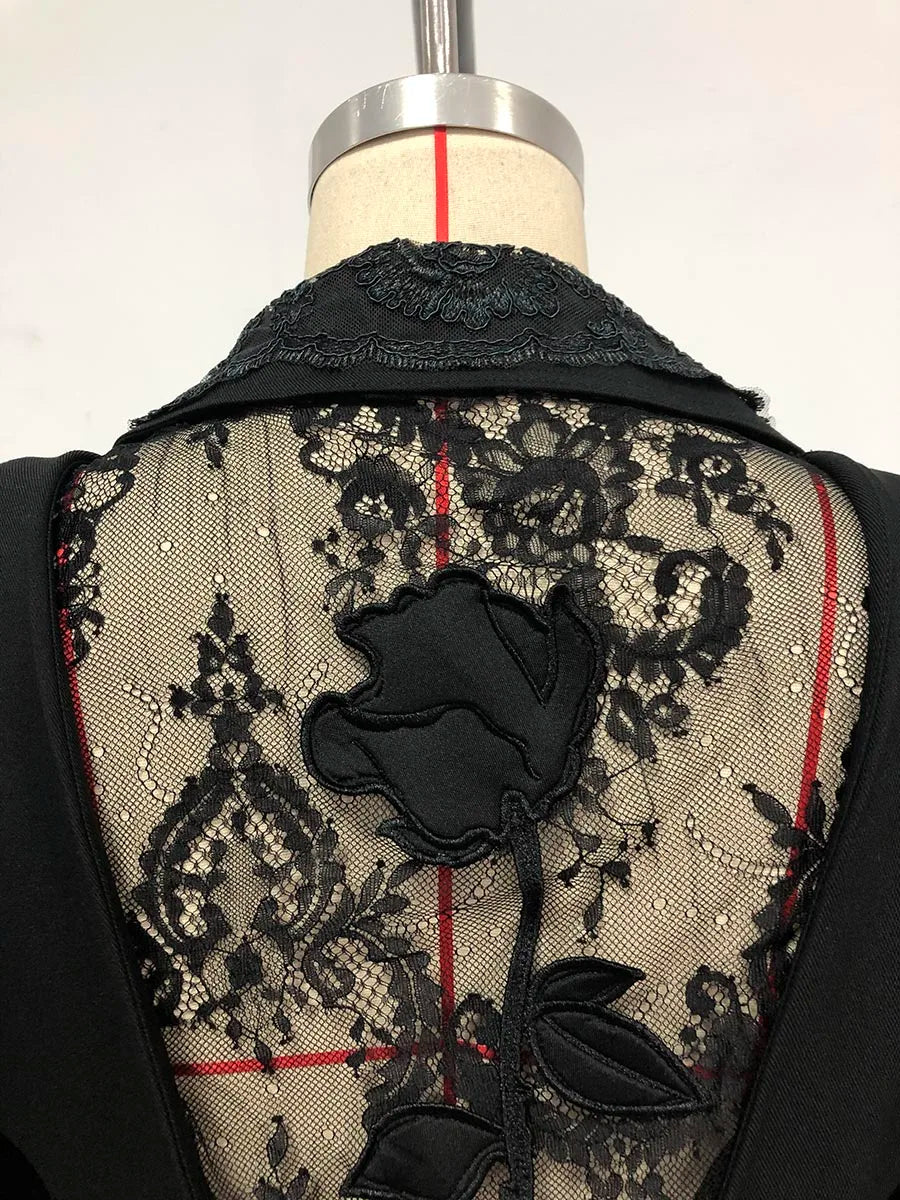 Black lace garment with floral design on a mannequin against a white background