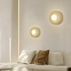 A Parisian-inspired round wall sconce with a milk white glass shade, casting a romantic glow  above a Sofa Bed.. A