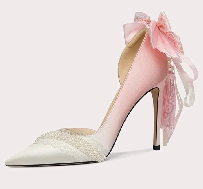 High-heeled shoe with a pink bow on a light gray background