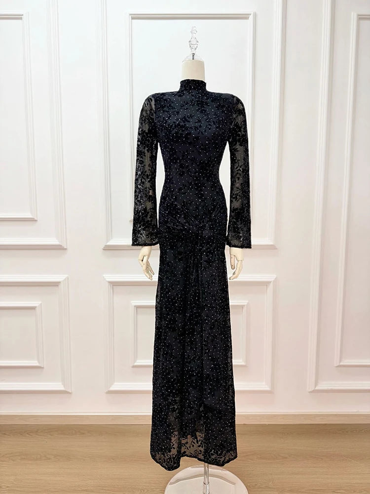 Black lace dress on a mannequin against a white paneled wall.