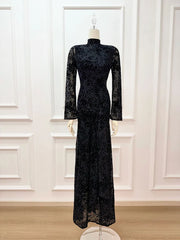 Black lace dress on a mannequin against a white paneled wall.