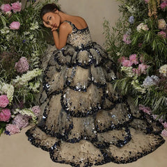 A model wearing a shimmering sequin butterfly layered gown with a flowing silhouette, perfect for special occasions. 10