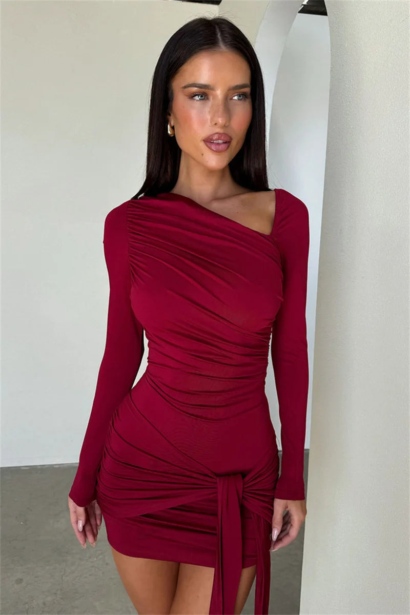 Woman wearing a burgundy one-shoulder dress with a white background