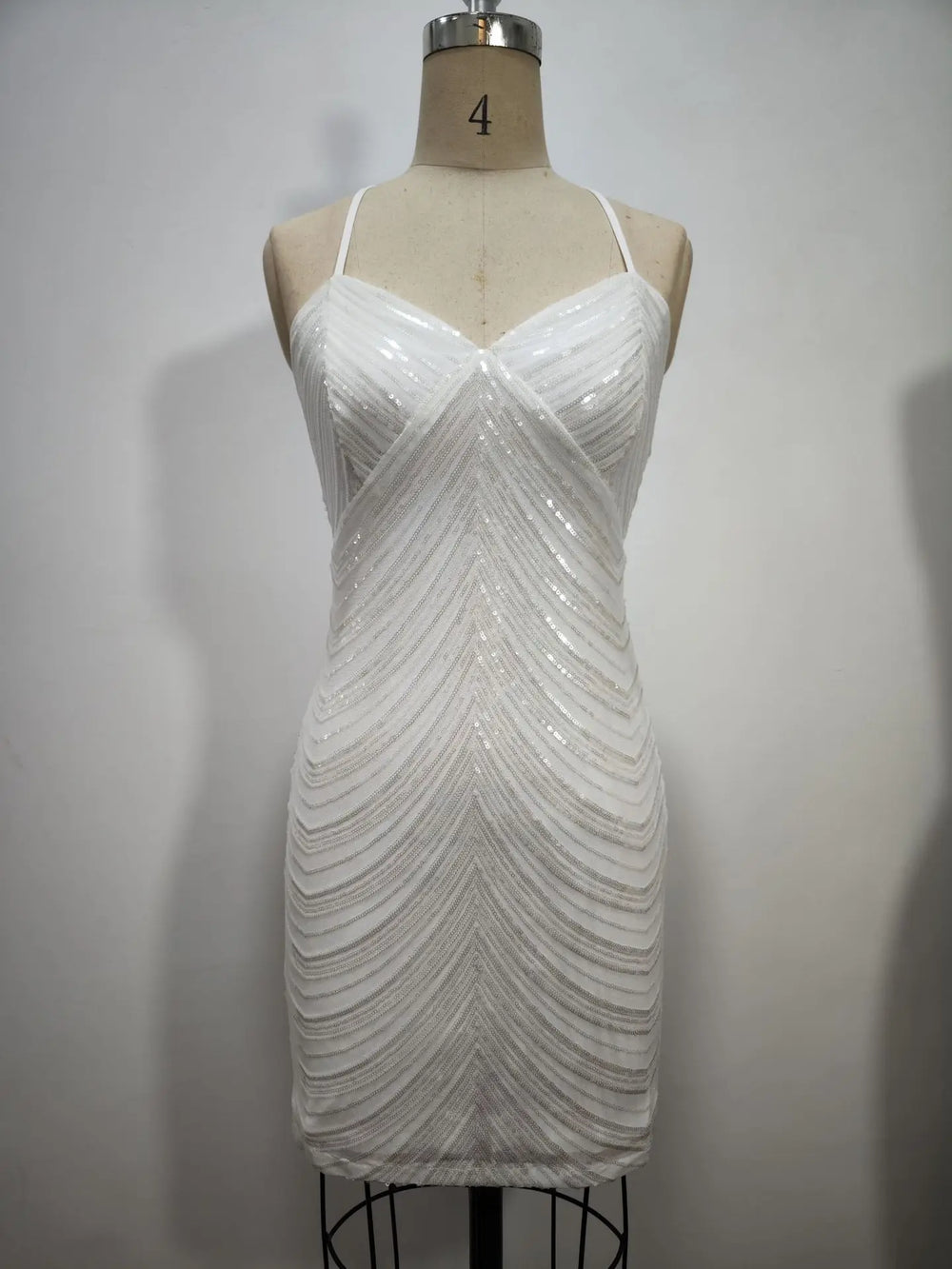 White sequin dress on a mannequin against a plain background