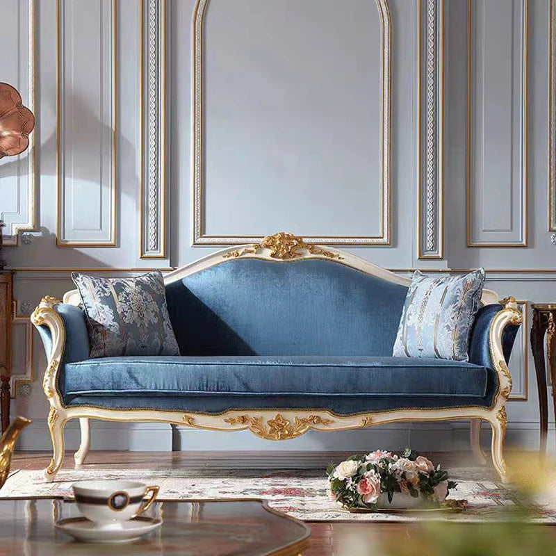 Blue velvet sofa with gold accents in a stylish room.