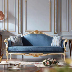 Blue velvet sofa with gold accents in a stylish room.