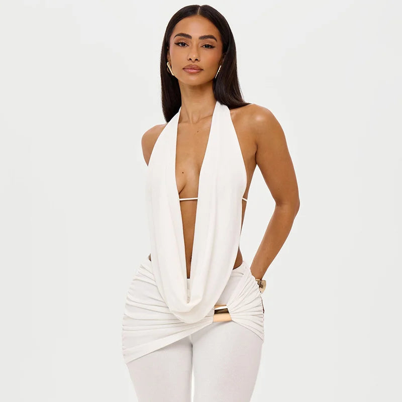 Woman wearing a white halter top with a deep neckline on a plain background