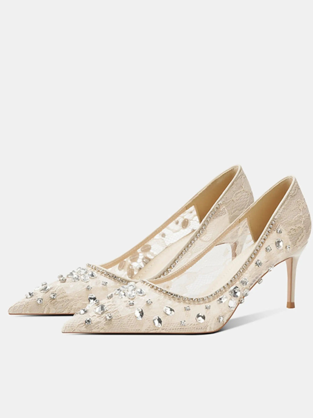 Pair of beige high-heeled shoes with floral embellishments on a white background
