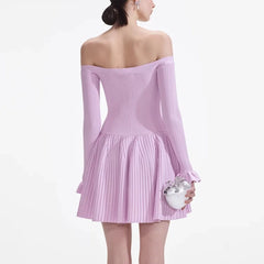 Woman wearing a light purple off-shoulder dress holding a silver clutch on a white background