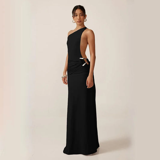 Woman wearing a black one-shoulder gown on a beige background
