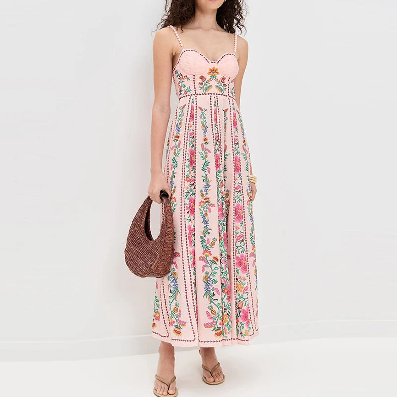 Woman wearing a floral dress holding a woven bag against a white background