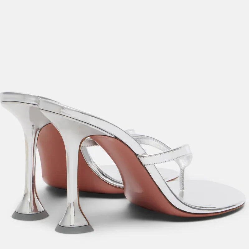 Pair of metallic flip flop heels showing the sculptural flared heel.