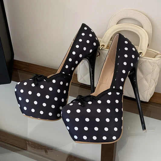 Black polka dot platform pumps with black trim and bow