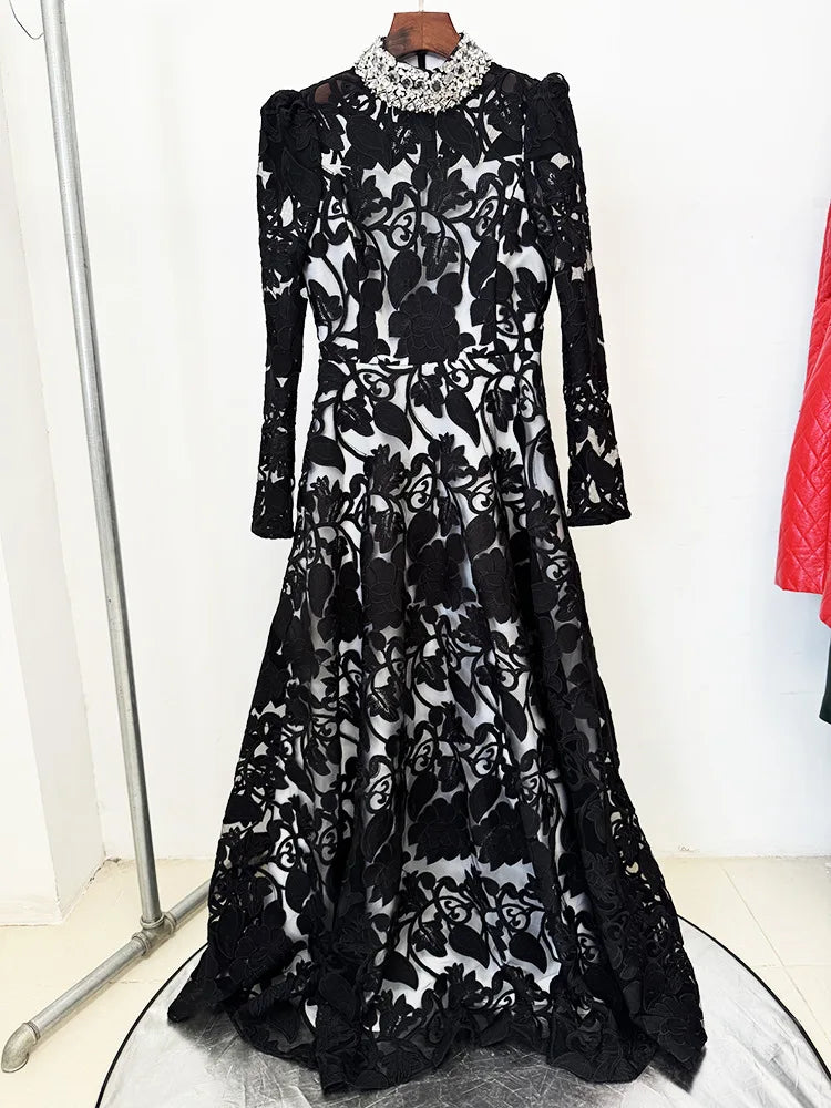 Black embroidered mesh maxi dress with beaded collar on a hanger.