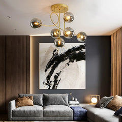 Modern living room with gray sofa, abstract painting, and gold chandelier.