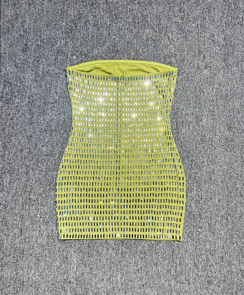 Green strapless dress with mesh design on a textured grey background