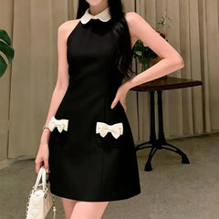 Black halter neck mini dress with white collar and white bow pockets