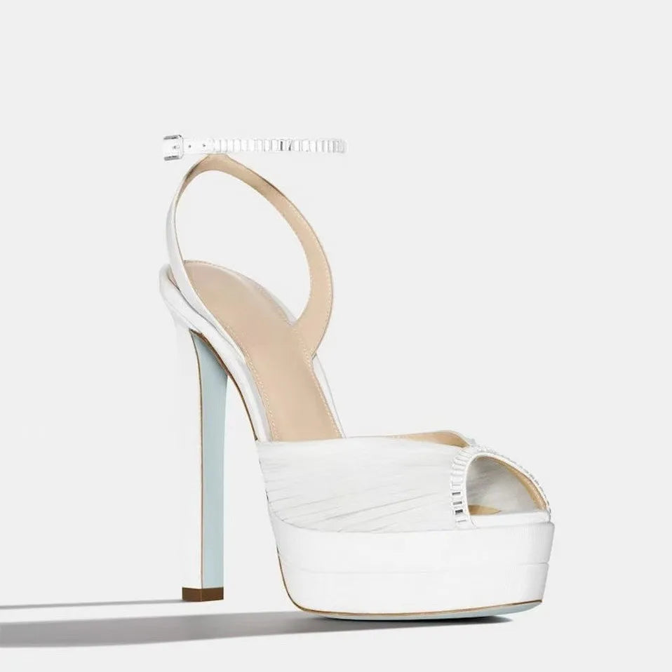 White platform rhinestone ankle strap heels, pleated satin upper, open toe.