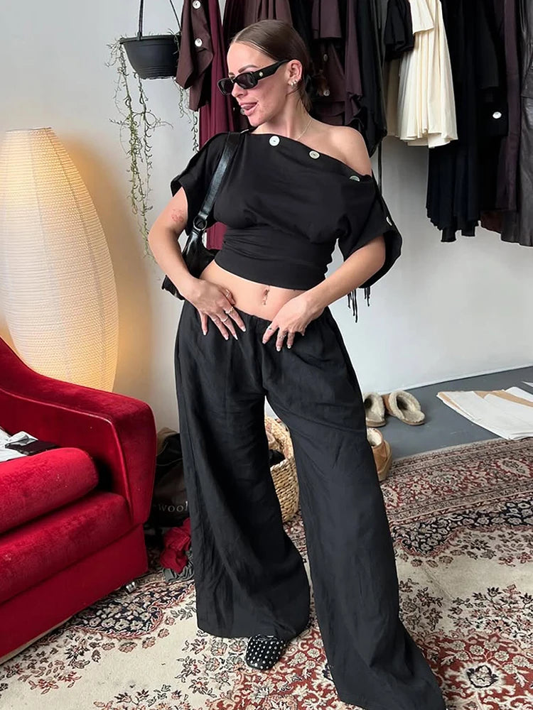 Model wearing black one shoulder top with wide leg pants