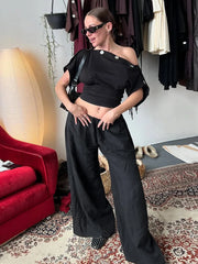 Model wearing black one shoulder top with wide leg pants