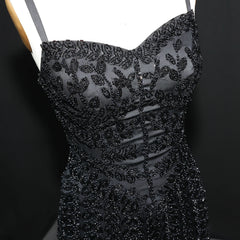 Black beaded dress on a mannequin against a dark background