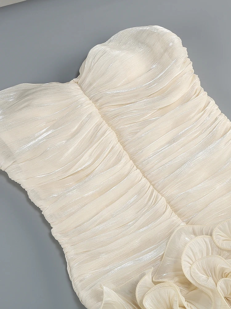 Close-up of a white dress with ruffled details on a gray background