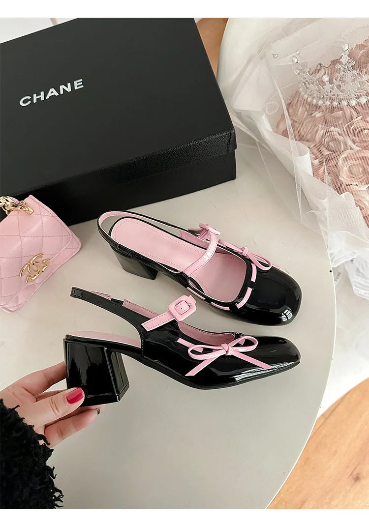 Black patent leather chunky Mary Jane heels with pink trim and bowknot detail.