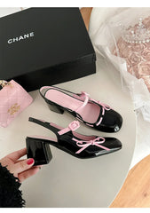 Black patent leather chunky Mary Jane heels with pink trim and bowknot detail.