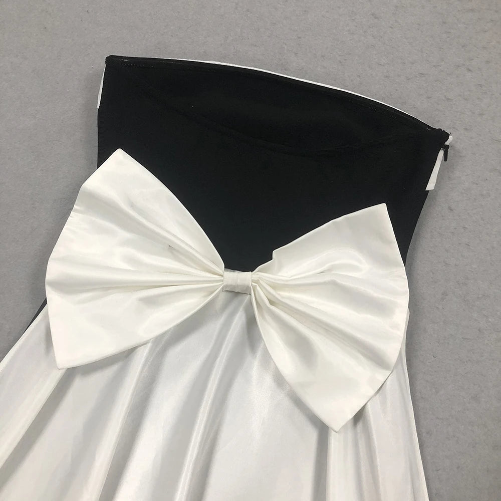 Black strapless dress with a large white bow on a gray background