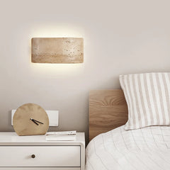 Bedroom with wooden headboard, nightstand, and wall light fixture.