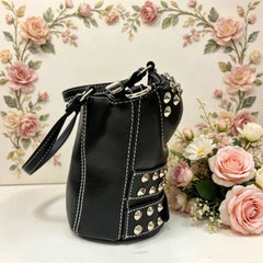 Side view of black studded buckled corset bag