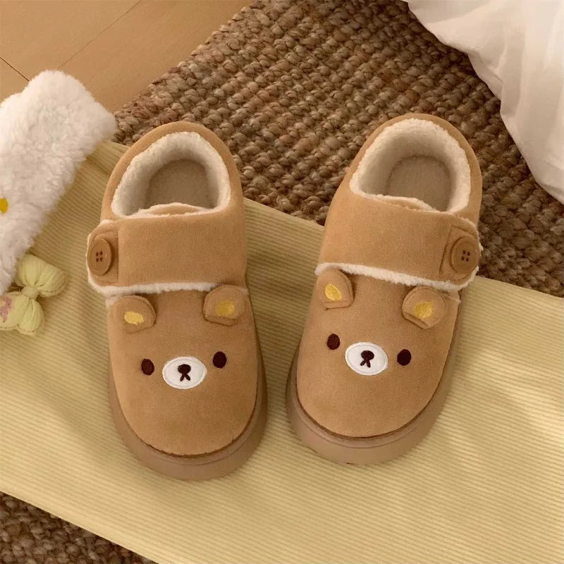 Brown cartoon bear house slippers on a woven rug.